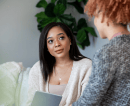 A woman with a tablet observing a therapist during an EMDR therapy session.
