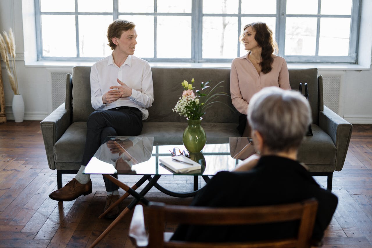 Services-03 Couple engaged in a therapy session with a counselor in a loft setting.