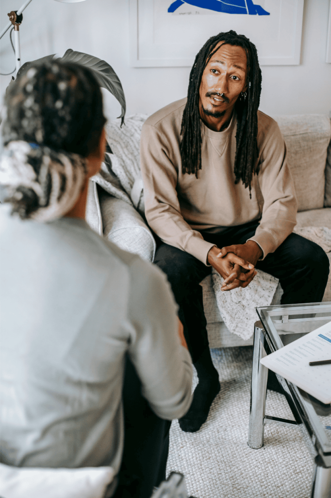 A female therapist and a male client sitting across from each other, engaged in a professional counseling session in a comfortable Medina office.